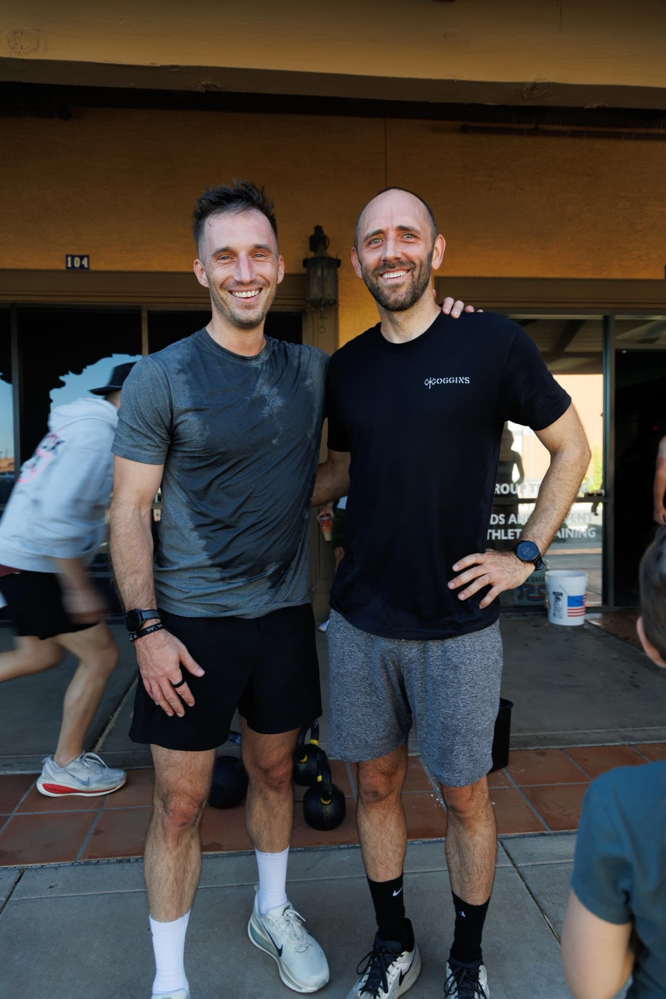 Two athletes smiling together after a class outside the AMP Fitness studio in Mesa, AZ.